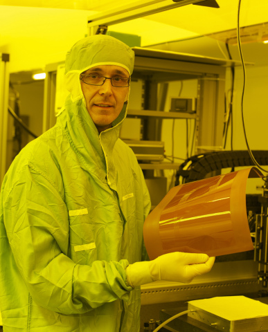 IBM scientist Roger Dangel holds a thin film polymer waveguide. IBM is experimenting with waveguides as a way to integrate silicon photonic chips into data center systems. Credit: IBM Research