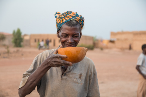 A woman drinks safe water from a RAIN project in her village outside Ouagadougou, Burkina Faso. (Photo: Business Wire)