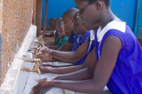 Children wash their hands before class begins at a school in Uganda. (Photo: Business Wire)