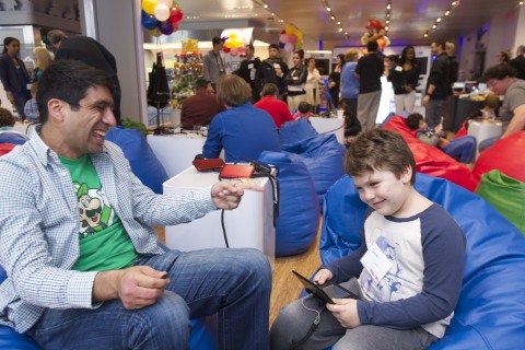 In this photo provided by Nintendo of America, Daniel O. of Nintendo of America and Dylan M., age 6, of Brooklyn, NY, lose themselves in the fun game play of Puzzle & Dragons Z + Puzzle & Dragons Super Mario Bros. Edition at an exclusive event at the Nintendo World store in New York on April 25, 2015. The two immersive puzzle games combine elements of match-three and RPG games, and are coming in one package to the Nintendo 3DS family of systems on May 22, 2015. A free demo for Puzzle & Dragons Super Mario Bros. Edition will be available on April 30, 2015.