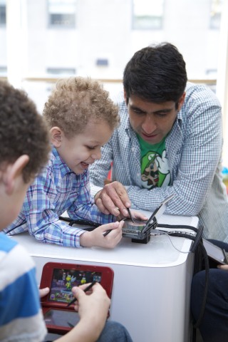 In this photo provided by Nintendo of America, Fox W. , age 4, of New York City and Daniel O. from Nintendo of America have fun playing and learning about Puzzle & Dragons Z + Puzzle & Dragons Super Mario Bros. Edition at an exclusive event at the Nintendo World store in New York on April 25, 2015. The two deep puzzle games combine elements of match-three and RPG games, and are coming in one package to the Nintendo 3DS family of systems on May 22, 2015.