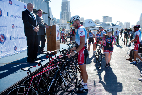 Dr. John Mateczun, president, UnitedHealthcare Military & Veterans (on stage, left) and Bruce Jasurda, communications vice president, UnitedHealthcare Military & Veterans (on stage, right) presented 16 replacement bikes to Ride 2 Recovery's Project HERO Balboa at a ceremony this morning on the U.S.S. Midway Flight Deck. Shawn Olin and Megan Whigham, members of Project HERO Balboa, are pictured choosing their bikes for the inaugural ride (Photo: Wally Nell).