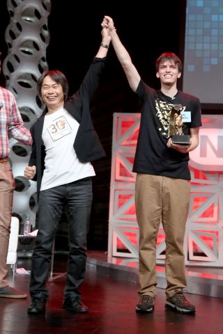 In this photo provided by Nintendo of America, 2015 Nintendo World Champion John Goldberg (R) of Queens, New York, receives the grand-prize trophy from video game developer Shigeru Miyamoto, creator of the Super Mario Bros., The Legend of Zelda and Donkey Kong series, among others. Fans in the audience and watching online celebrated the return of the event after a 25-year hiatus and cheered on 16 contestants as they competed across a variety of Nintendo video games. (Photo: Nintendo)