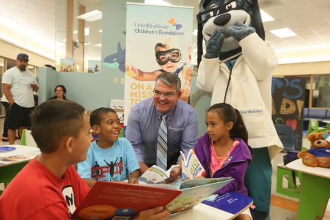 (L-R) Gavin Benzon (9) reads from the Oliver & Hope Superhero Saturday children’s book to Javon Rivera (7), Tom Chohany of UnitedHealthcare and Sophia Benzon (8) during a reading circle that took place at the Naval Medical Center San Diego (NMCSD). At the event, UnitedHealthcare announced it is donating 40 UnitedHealthcare Children’s Foundation (UHCCF) reading stations and nearly 1,000 Oliver & Hope books as part of a summer reading initiative to health clinics, medical centers and doctor’s offices throughout San Diego to encourage early reading and healthy living among children. NMCSD is receiving 10 reading stations, as well as books and children’s activity booklets, which will be placed in patient waiting areas in the hospital (Photo: Sandy Huffaker).