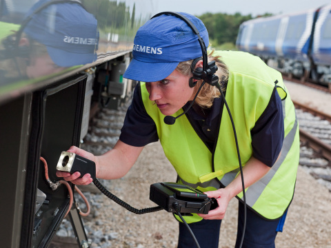 A Siemens service technician inspects the wheel systems on a rail locomotive. (Photo: Business Wire)
