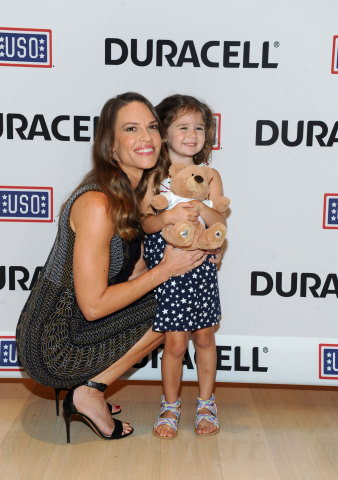 Hilary Swank, actress and daughter of a retired Air Force Senior Master Sergeant, hugs Mackenzie, 3, daughter of Navy Air Traffic Controller First Class Robert Nilson, at the premiere of Duracell's new film, The Teddy Bear, that shines a light on military families and supports the USO, Thursday, July 2, 2015, at The Times Center in New York. The film, inspired by the Nilsons, was released in time for the July Fourth holiday weekend and can be viewed at youtube.com/Duracell. (Photo by Diane Bondareff/Invision for Duracell/AP Images)