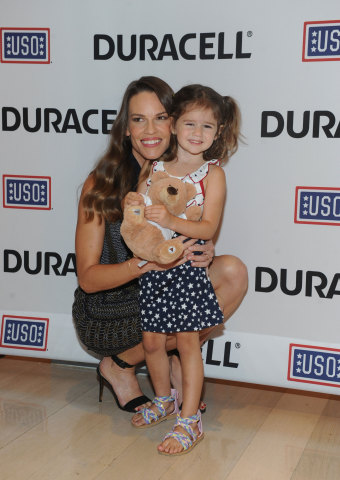 Hilary Swank, actress and daughter of a retired Air Force Senior Master Sergeant, hugs Mackenzie, 3, daughter of Navy Air Traffic Controller First Class Robert Nilson, at the premiere of Duracell's new film, The Teddy Bear, that shines a light on military families and supports the USO, Thursday, July 2, 2015, at The Times Center in New York. The film, inspired by the Nilsons, was released in time for the July Fourth holiday weekend and can be viewed at youtube.com/Duracell. (Photo by Diane Bondareff/Invision for Duracell/AP Images)