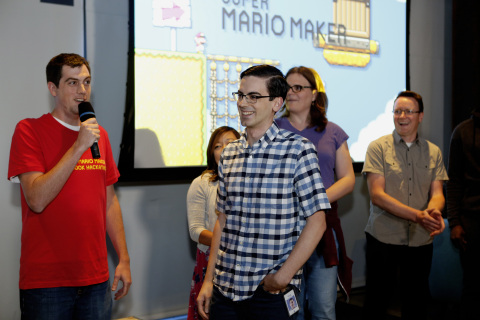 In this photo provided by Nintendo of America, Corey Olcsvary from the Nintendo Treehouse announces winners Doug Strait, center, and Roy McElmurry (not pictured), who designed the winning Super Mario Maker level, "Ship Love," created during a "hackathon" event at Facebook Headquarters in Menlo Park on Wednesday, July 29, 2015. More than 150 of Facebook's best and brightest employees created their unique take on Super Mario Bros. levels for the upcoming Super Mario Maker game for Nintendo's Wii U home console. The top level, as selected by Nintendo and Facebook judges, will be made available to players for free shortly after the game launches on the 11th of September. (Photo by Alison Yin/Invision for Nintendo/Facebook/AP Images)
