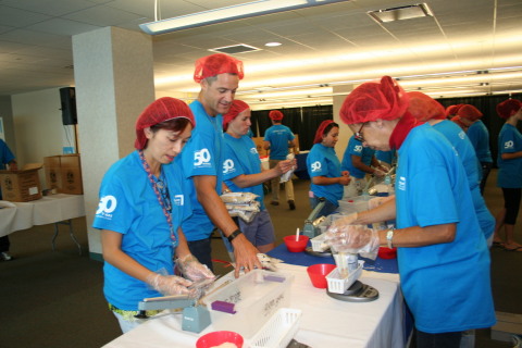Lexington Insurance President & CEO, Jeremy Johnson (center), works with Lexington Insurance Company employees to assemble and package 40,000 meals for Stop Hunger Now to feed the hungry. Lexington Insurance celebrated its 50th anniversary Wednesday, Aug. 12, at its Boston headquarters volunteering for Stop Hunger Now and other charities. (Photo: Business Wire)