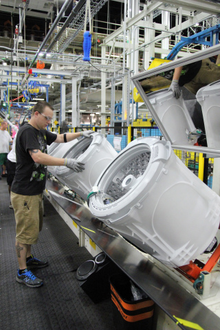 Team member Brad Tingle secures the tub cover on the new GE topload washers made in Louisville, Kentucky. (Photo: GE)
