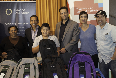 Mayor Antonio Villaraigosa (left) and Banc of California CEO and President, Steve Sugarman, (center) hand out school supplies to Partnership for LA Schools families during the launch of financial literacy program at Santee Education Complex in South LA. They were joined by Partnership for LA School's CEO, Joan Sullivan, (second from the right) and Santee Education Complex Principal, Dr. Martin Gomez (right). Photo Credit: Albert Campbell