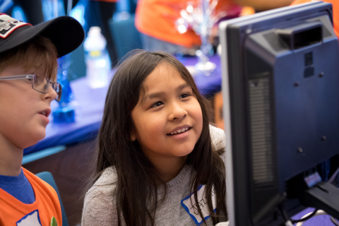 Volunteer Logan Serino, son of MetLife Associate Jason Serino, teaches Jazmine Serrato some of the new programs and features of the computer she received at the "MetLife Geek-A-Thon" on Saturday, October 24, 2015 at the MetLife Global Technology Campus in Cary, N.C. (Photo: Business Wire)