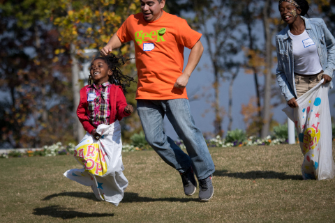 Students Laurina and Patience Tamba join volunteer Saul Gatica (center) for fun and games at the second annual "MetLife Geek-A-Thon" on Saturday, October 24, 2015 at the MetLife Global Technology Campus in Cary. MetLife volunteers refurbished and donated more than 400 computers to North Carolina students. (Photo: Business Wire)