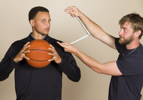 Golden State Warriors point guard and 2015 NBA MVP Stephen Curry poses with a basketball as a Madame Tussauds artisan takes his measurements. (Photo: Business Wire)