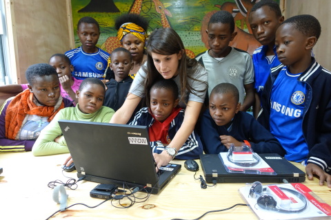 Children from the Tuleeni Orphanage in Tanzania learn to use the new computers in their mobile classroom with help from Neema International founder and executive director Mandy Stein. (Photo: Business Wire)