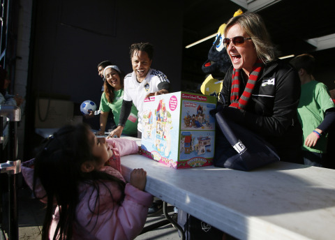 Herbalife employees hand out toys at A Place Called Home's annual toy distribution event. (Photo: Business Wire)