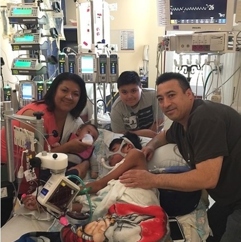 2015 was a year of dramatic changes for Oswaldo and his family, seen here at his bedside, post-transplant surgery in July. (Photo: Business Wire)