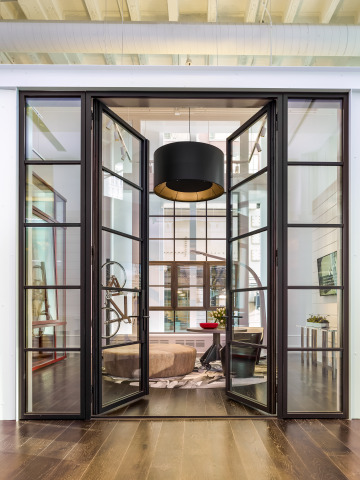 The Pella Crafted Luxury showroom artfully displays windows and doors within six style vignettes, including the Urban Loft. The steel windows and doors with black aluminum clad exteriors are a dramatic feature of the Urban Loft room. (Photo: Pella Corporation)
