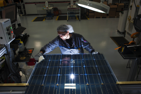 A worker at SolarWorld Americas Inc., based in Hillsboro, Oregon, inspects a bifacial Bisun laminate before it is framed to become a two-sided solar panel in the company's first production run of the new technology. Bisun solar technology captures both direct solar radiation on its front side as well as indirect sunlight on its back side, producing up to 25 percent more energy than standard solar panels of the same nominal wattages. This panel was among shipments for a system at the University of Richmond in Virginia. (Photo: Business Wire)