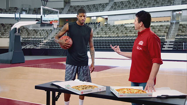 Indiana Pacers All-Star Paul George shows "Papa John" Schnatter how to dunk in a new marketing campaign from Papa John's International, Inc.