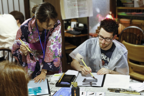 A traveler to learn calligraphy from students (Photo: Business Wire)