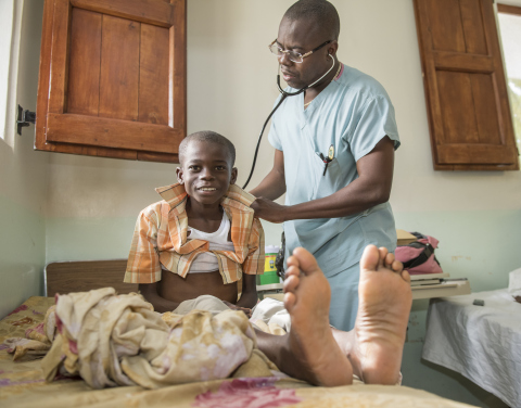 A doctor at Hospital Lumière at Bonne Fin, Haiti, uses a stethoscope to check on a young patient there. The hospital is now operating on a reliable power system largely supplied with energy via SolarWorld solar panels. Credit: Eric Forberger for SolarWorld