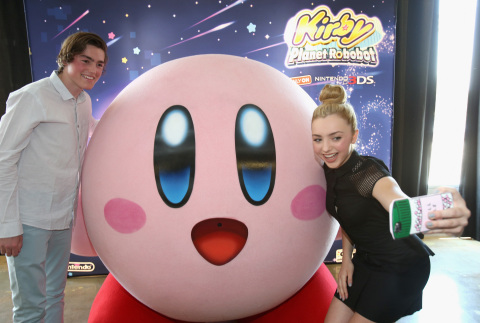 In this photo provided by Nintendo of America, Peyton List from Disney's "Bunk'd' who is starring in the upcoming feature "The Thinning" and Spencer List from "The Bachelors" interact with Kirby at the Kirby: Planet Robobot celebration at Smashbox Studios in Culver City, California, on June 22, 2016. Kirby: Planet Robobot, the latest instalment in the popular franchise, available now for the Nintendo 3DS family of systems.