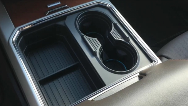 Ford engineers have received a patent for a unique cupholder design between the front seats. The design has two main components - a combination cupholder and storage bin with upper panel that slides from left to right to transform the storage bin into two additional cupholders.