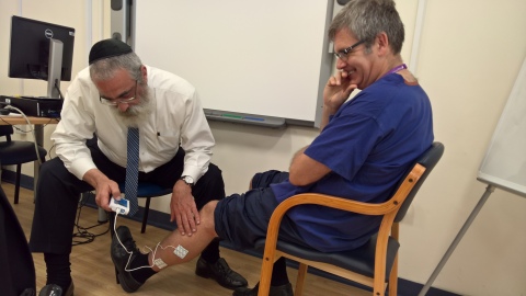 Dr. Graham Bowen, Head of Podiatry & Clinical Services Manager at Solent NHS Trust in Southampton UK trying out FlowAid's FA100 SCCD. Jacob Brezel, CEO, at left operating the device. (Photo: Business Wire)