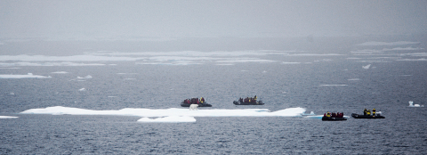 Crystal guests encounter a polar bear on ice while navigating zodiacs with expert guides – Captain Birger J. Vorland 
