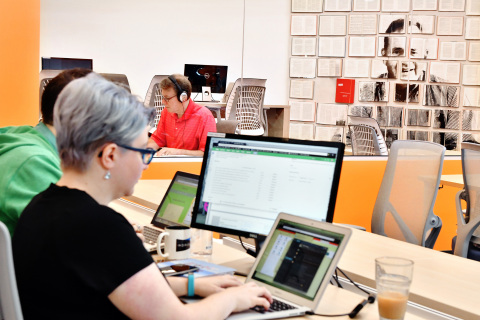 Workbar Members work beside a mural of Staples Founder Thomas G. Stemberg in the commons area of the Workbar at Staples location on Tues., Sept. 13, 2016 in Brighton, Mass. Each of the three Massachusetts Workbar at Staples locations feature productive coworking spaces that include unique artwork reflecting the local community. (Josh Reynolds /AP Images for Staples)