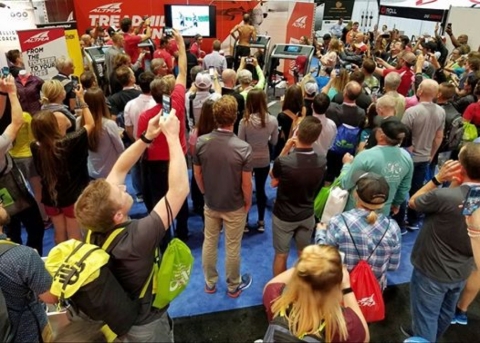A huge crowd of fellow runners gathers at The Running Event, a trade show for run specialty retailers, to watch Altra athlete Jacob Puzey break the world record for fastest 50-miler on a treadmill. Puzey is at the very top center of the photo, shirtless, on the treadmill. (Photo: Altra)