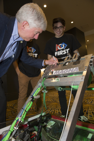 Michigan Gov. Rick Snyder signs a Detroit-based FIRST team's robot during a press event to announce the arrival of FIRST Championship in Detroit starting in 2018. (Photo: Business Wire) 