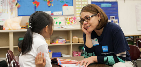Schwab employee Elinore Robey provides a lesson in saving to a Garfield Elementary School student in Oakland, California.(Photo: Business Wire)