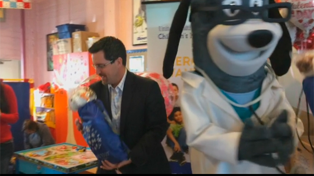 Local children receive a Valentine's Day-themed Grins 2 Go™ bag from Kevin Kandalaft of UnitedHealthcare at Wellspring Women's Center on Monday, Feb. 13. Wellspring serves as a drop-in center to women and their children, providing food and social services in a safe and enriching environment (Video: Anita Sen).