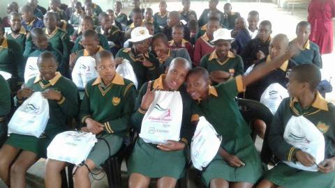 Young girls pose with their free sanitary pads and school supplies. (Photo: Business Wire)