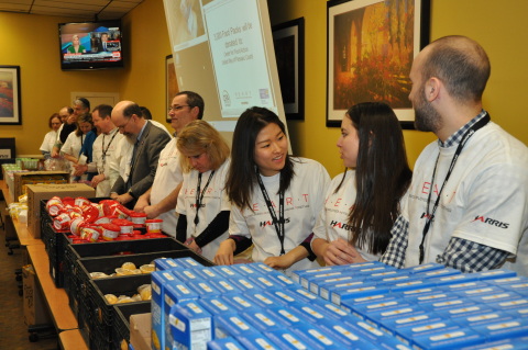 Harris Corporation employees in Clifton, New Jersey, help assemble food packs as part of a company-sponsored service event to support low-income children. (Photo: Business Wire)