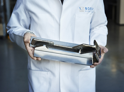 A Norsk Titanium Scientist Displays a Boeing 787 Dreamliner Structural Component to Demonstrate the Near-Net-Shape RPD Buy-to-Fly Ratio (Photo: Business Wire)