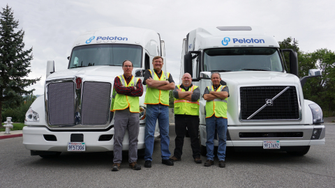 Peloton Drivers in front of Peloton-equipped Volvo and Kenworth trucks. (Photo: Business Wire)