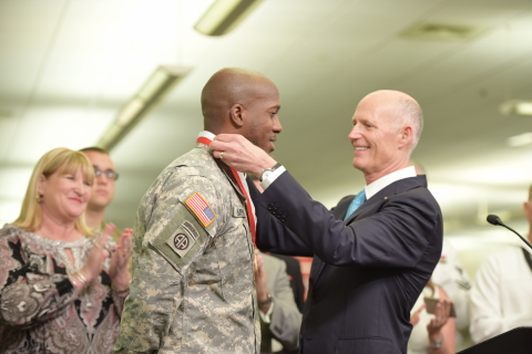 Florida Governor Rick Scott presents Jeffrey Clement, Comcast technician and member of the U.S. Army Reserves, with the Governor’s Veterans Service Award. (Photo: Business Wire)
