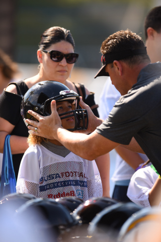 Riddell representative educates young athlete and parent on proper equipment fitting at USA Football Protection Tour. (Photo: Business Wire)