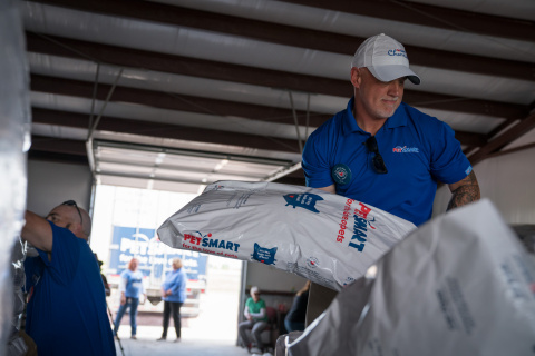 Sean Cuddeback, Store Leader of a Colorado Springs, Colo., PetSmart store, helps unload a semi-truck full of 250,000 pet food meals for dogs and cats in need at Rescue Bank affiliate, St. Paws, and adjacent shelter, National Mill Dog Rescue in Peyton, Colo., a suburb of Colorado Springs, Colo. PetSmart just announced its initial shipments - three semi-truck loads of donated pet food - delivered in the past few days as part of nearly 90 semi-truck loads to be donated this summer from PetSmart's Buy a Bag, Give a Meal program, where the retailer is giving a meal to a pet in need for any and every bag of dog or cat food purchased through Dec. 31, 2017, in its more than 1,500 stores and online at PetSmart.com and PetSmart.ca. Through this historic philanthropic program, PetSmart expects to donate more than 60 million meals to pets in need with semi-truck deliveries of donated pet food throughout 2017 and well into 2018. With PetSmart Charities and its partners Feeding America and Rescue Bank, the much-needed food will land at hundreds of locations across North America including local shelters and rescues, as well as to food banks and pantries where pet food is a rare offering. (Photo: Business Wire)