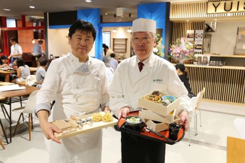 In front of the "Tsuruoka Bar," that is consisted of a restaurant that serves local delicacies, a sushi restaurant that serves sushi with freshly caught fish, a Spanish-style bar, and a wine/Japanese Sake bar. Chef Masayuki Okuda (Left) from "Farinamore," a pasta and dolce restaurant and Head Chef Mr. Masatomi Toki (Right) from "Ayatsuru," a restaurant that serves local Tsuruoka cuisines. (Photo: Business Wire)