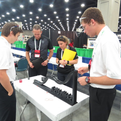 Joshua Martelle and Denver Wiederin, Center for Technology, Essex test their prototype in front of the Additive Manufacturing Competition judges (Photo: Business Wire)