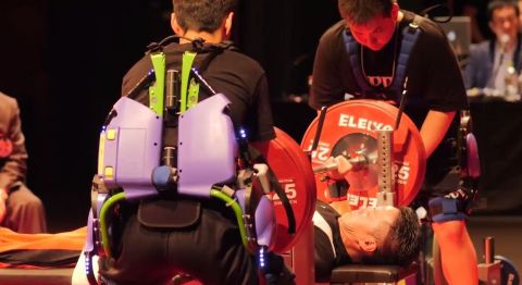 In the experiment, staff who assisted in placing/removing the plates onto/from the bar wore a Power Assist Suit to demonstrate its ability to help lighten the load and to confirm the feasibility of using the suit at actual sports competitions. (Photo: Business Wire)
