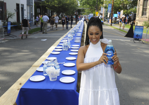Actress Tia Mowry stands by a 2,000 foot table holding over 6,000 dishes at the Family Dinner with Dawn event in Lambertville, NJ, Sunday, Aug. 13, 2017, to demonstrate how one 21.6 oz bottle of Dawn can wash an entire town's dishes. (Photo by Diane Bondareff/Invision for Dawn/AP Images)