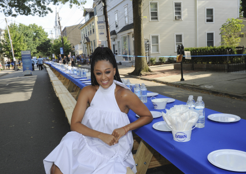 Actress Tia Mowry sits at a 2,000 foot table holding over 6,000 dishes at the Family Dinner with Dawn event in Lambertville, NJ, Sunday, Aug. 13, 2017, to demonstrate how one 21.6 oz bottle of Dawn can wash an entire town’s dishes. (Photo by Diane Bondareff/Invision for Dawn/AP Images)