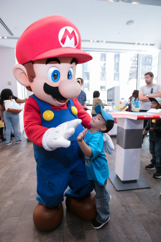 In this photo provided by Nintendo of America, Alessandro A., age 4, from Woodside, NY, greets Mario at the Nintendo NY store during the Nintendo Back-to-School Celebration. (Photo: Business Wire)