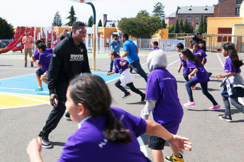 Jared Cook of the Oakland Raiders played a game of tag with students at International Community School in Oakland Monday. Cook and UnitedHealthcare employees unveiled new physical education equipment and other beautification projects for students at the school (Photo: Amy Sullivan).