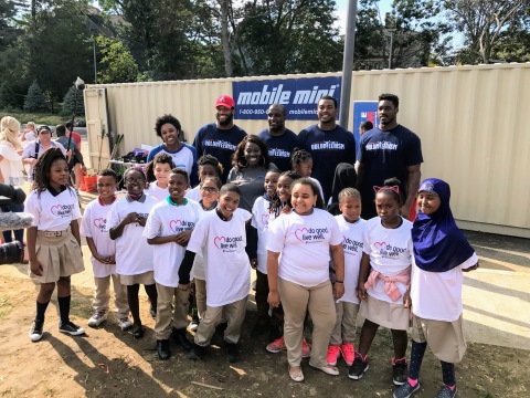 New England Patriots players (L-R) Deatrich Wise, David Harris, Adam Butler and Geneo Grissom huddle with students from Bridge Boston Charter School following today's volunteer project where the athletes worked with volunteers from UnitedHealthcare and nonprofit KaBOOM! to build a playground at Bridge Boston Charter School (Photo: UnitedHealthcare).